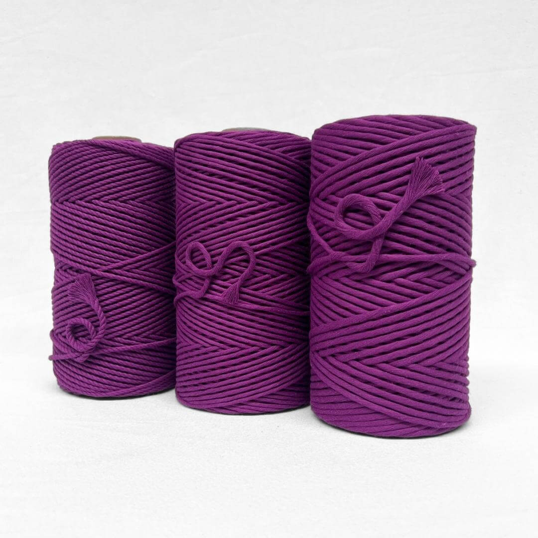 one roll of vibrant grape purple 4mm recycled macrame cord in white background small brushed piece showcasing products softness
