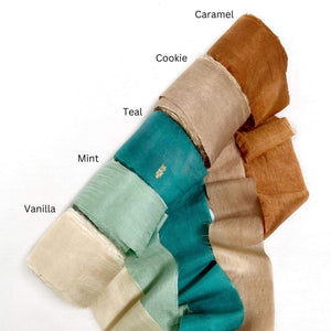 caramel cookie brown teal mint vanilla silk ribbon unravelled on white background