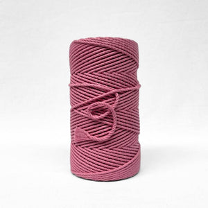 bright pink barbie pink cotton cord in image with single roll standing upright on white background