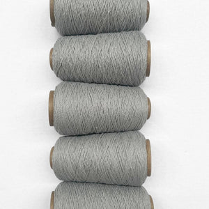Duck egg blue wool yarn in flat ay image showing 5 rolls of same colour laying side by side vertically down image on white background.
