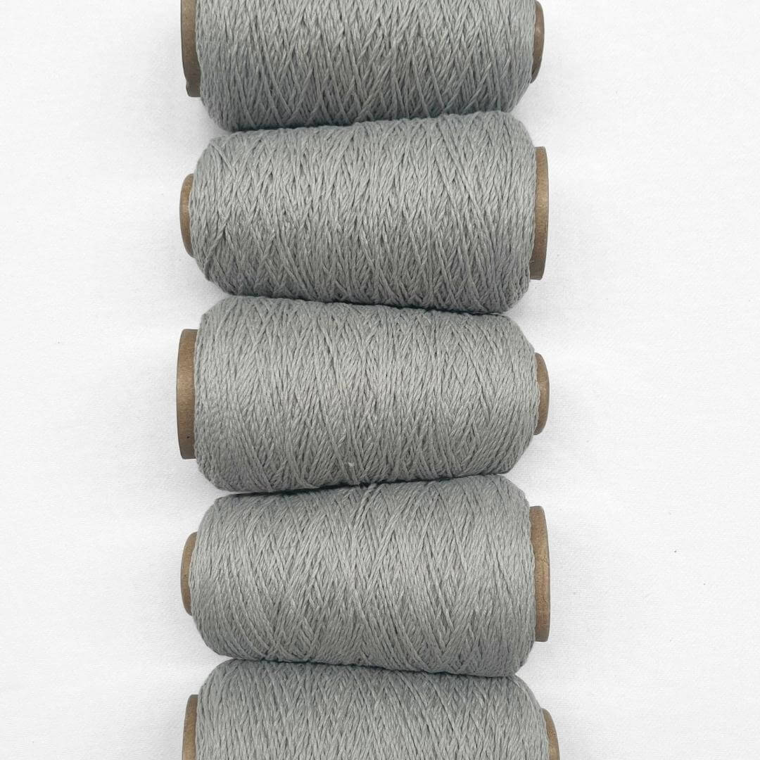 Duck egg blue wool yarn in flat ay image showing 5 rolls of same colour laying side by side vertically down image on white background.