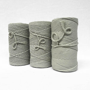 three rolls of mist green standing side by side showcasing different variations of the product on white wall
