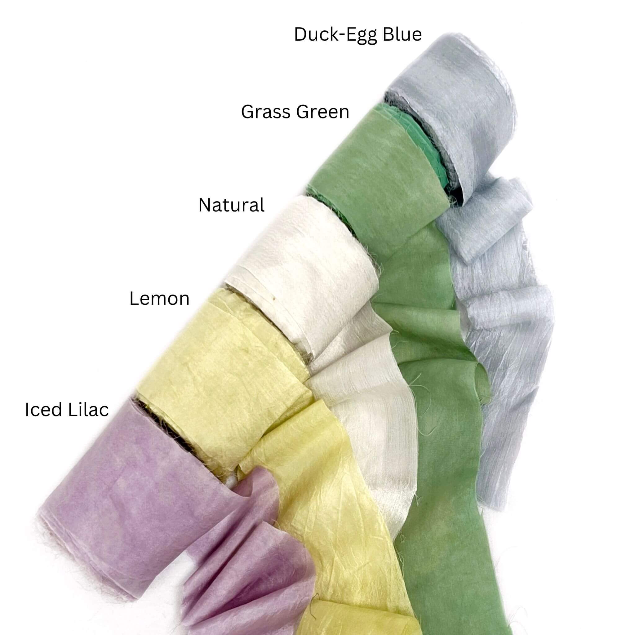 duck egg soft blue grass green natural white lemon yellow iced lilac silk roll in group photo with five colours unravelled on white back drop