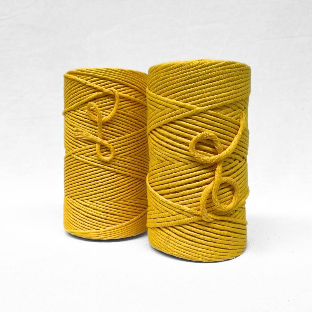 3mm and 5mm cotton string rolls in bright sunflower yellow standing next to each other showing size difference in white background