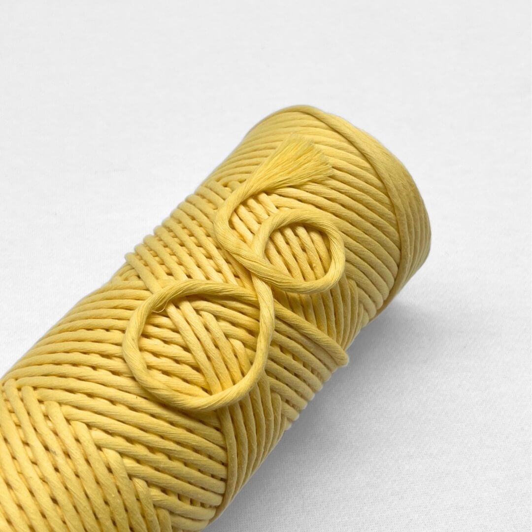 roll of butery yellow string laying flat on white background
