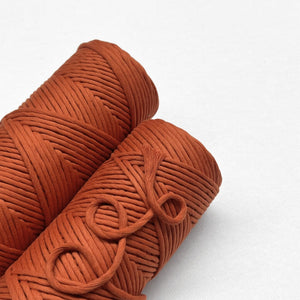 red earth macrame cord two rolls laying flat side by side on white backdrop
