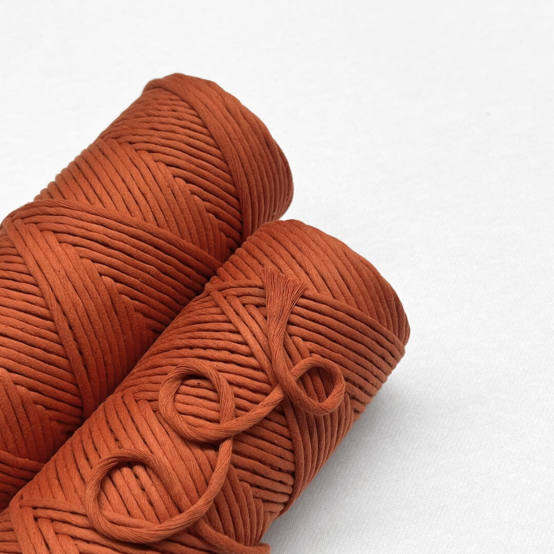 red earth macrame cord two rolls laying flat side by side on white backdrop