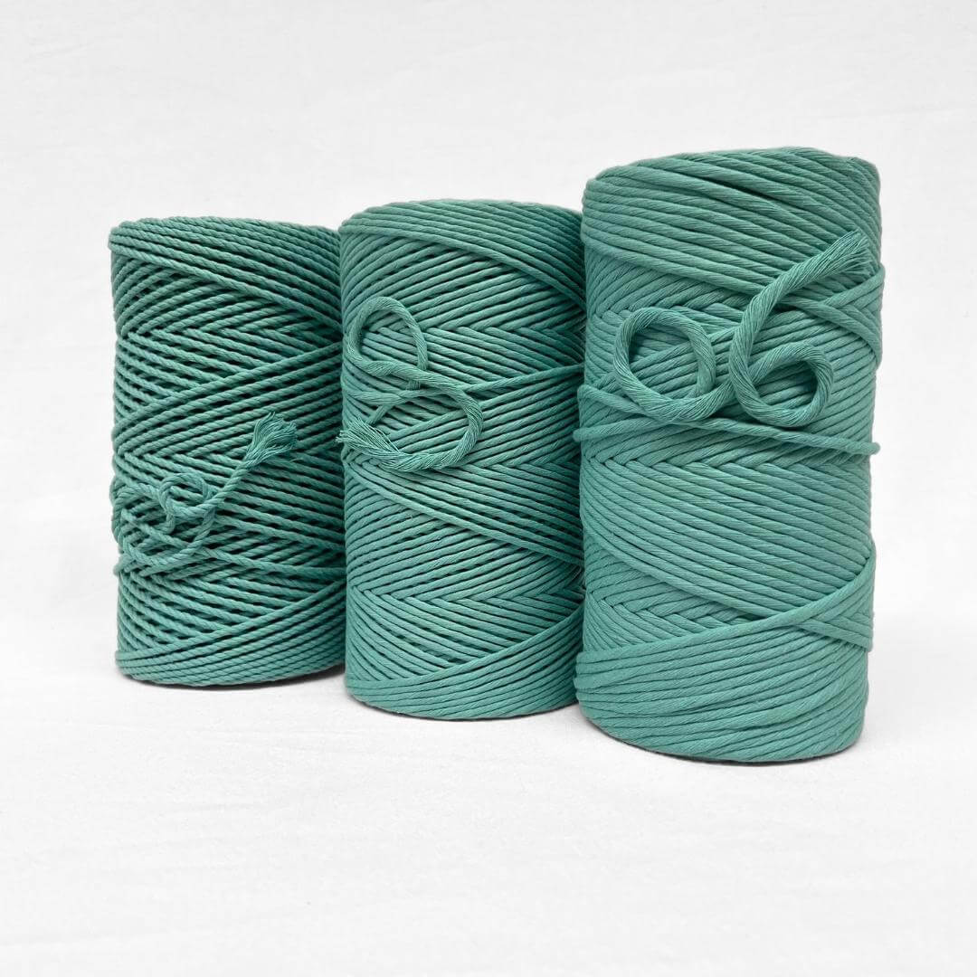 turquoise blue 4mm 3ply cotton cord image showcasing single rolls standing upright on white background