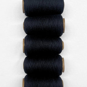5 rolls of black wool rope laying side by side on white background