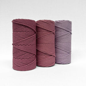 three rolls of 4mm braided rope in colours plum pink primrose pink and orchid standing on angle with white background