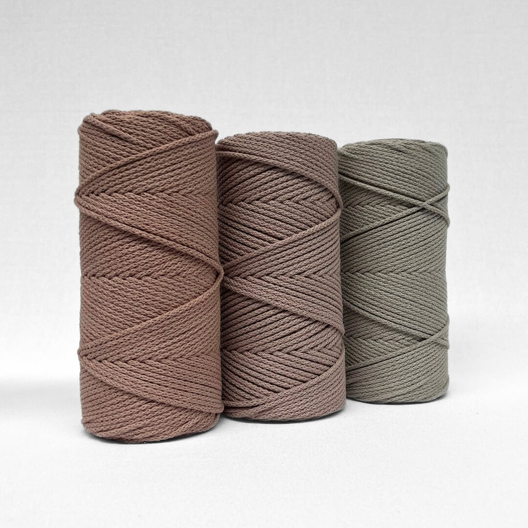 three rolls of 4mm braided rope in colours plum pink primrose pink and orchid standing on angle with white background