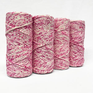 hot pink water colour cotton cord four rolls standing next to each other showing variation between each rolls on white background