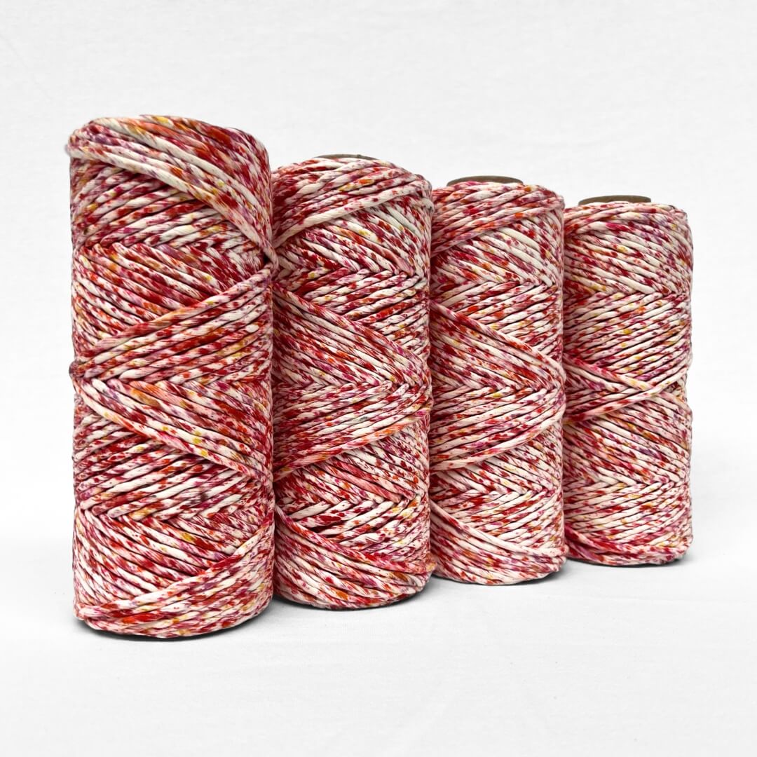 combination photo showing four rolls of vibrant red yellow and orange confetti cotton cord standing upright on white background