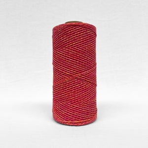 image of a single roll of 1.5mm mixed macrame string warp in sunburst colour way standing upright on white background