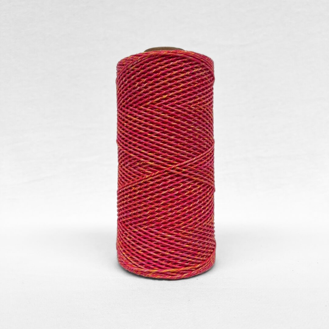 image of a single roll of 1.5mm mixed macrame string warp in sunburst colour way standing upright on white background