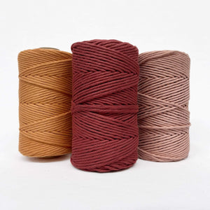 caramel deep red and vintage peach cotton string rolls in combination photo on white background