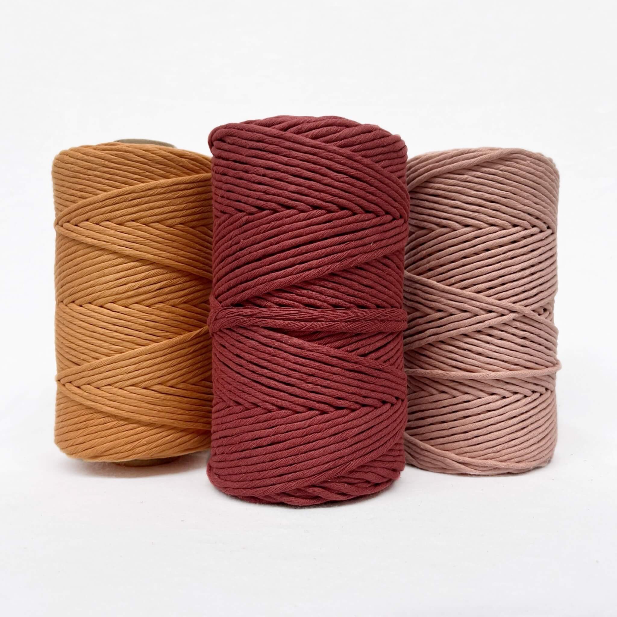 caramel deep red and vintage peach cotton string rolls in combination photo on white background