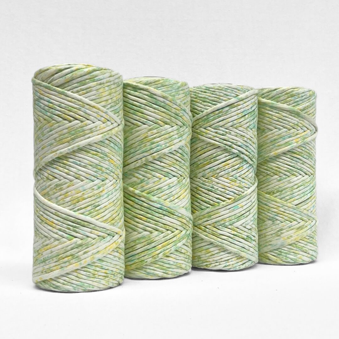 four rolls of lime splice watercolour macrame string standing upright on white background