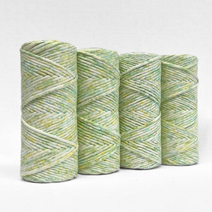 four rolls of lime splice watercolour macrame string standing upright on white background