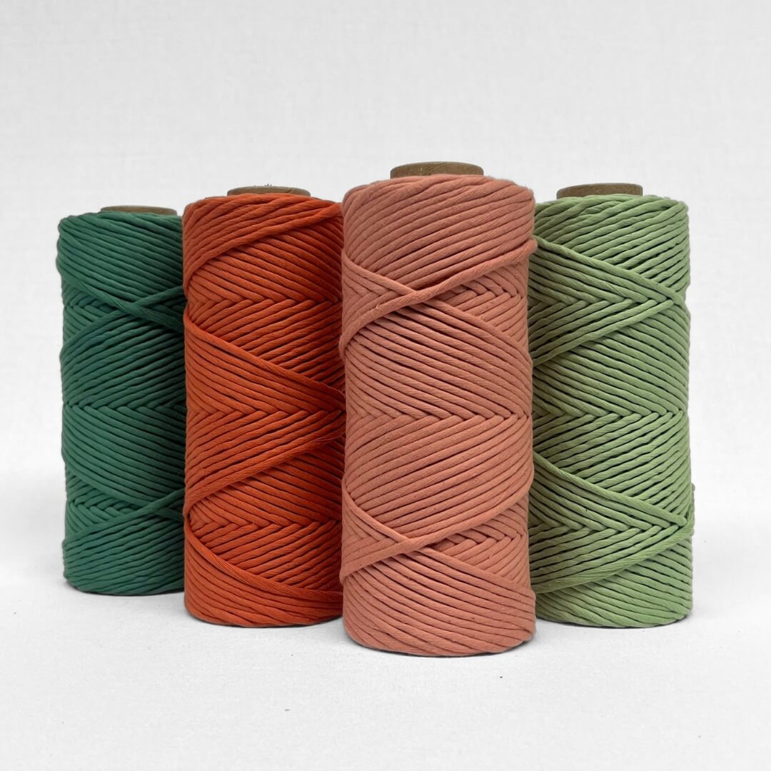 single roll of rosewood macrame 4mm string laying flat and angled on white background with small curled piece highlighting texture