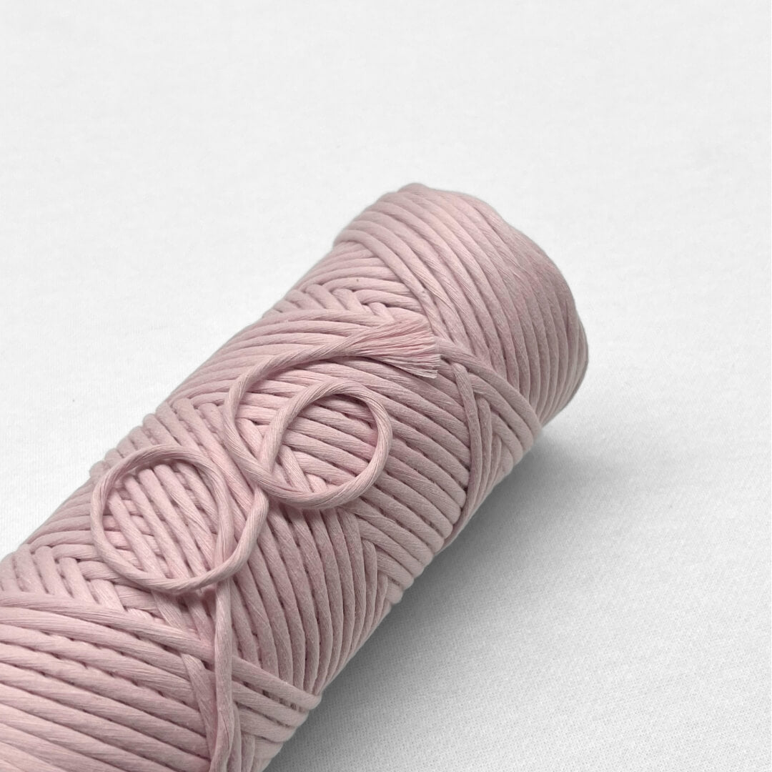 Frosted Pink macrame cotton string laying flat on white background