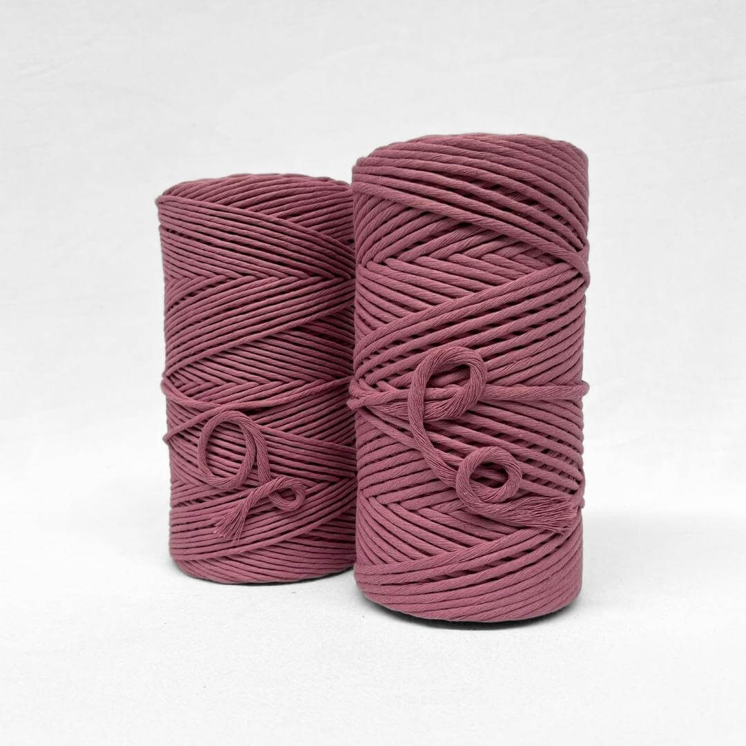 two rolls of plum pink 1kg cotton string standing up in 3mm and 5mm on white background