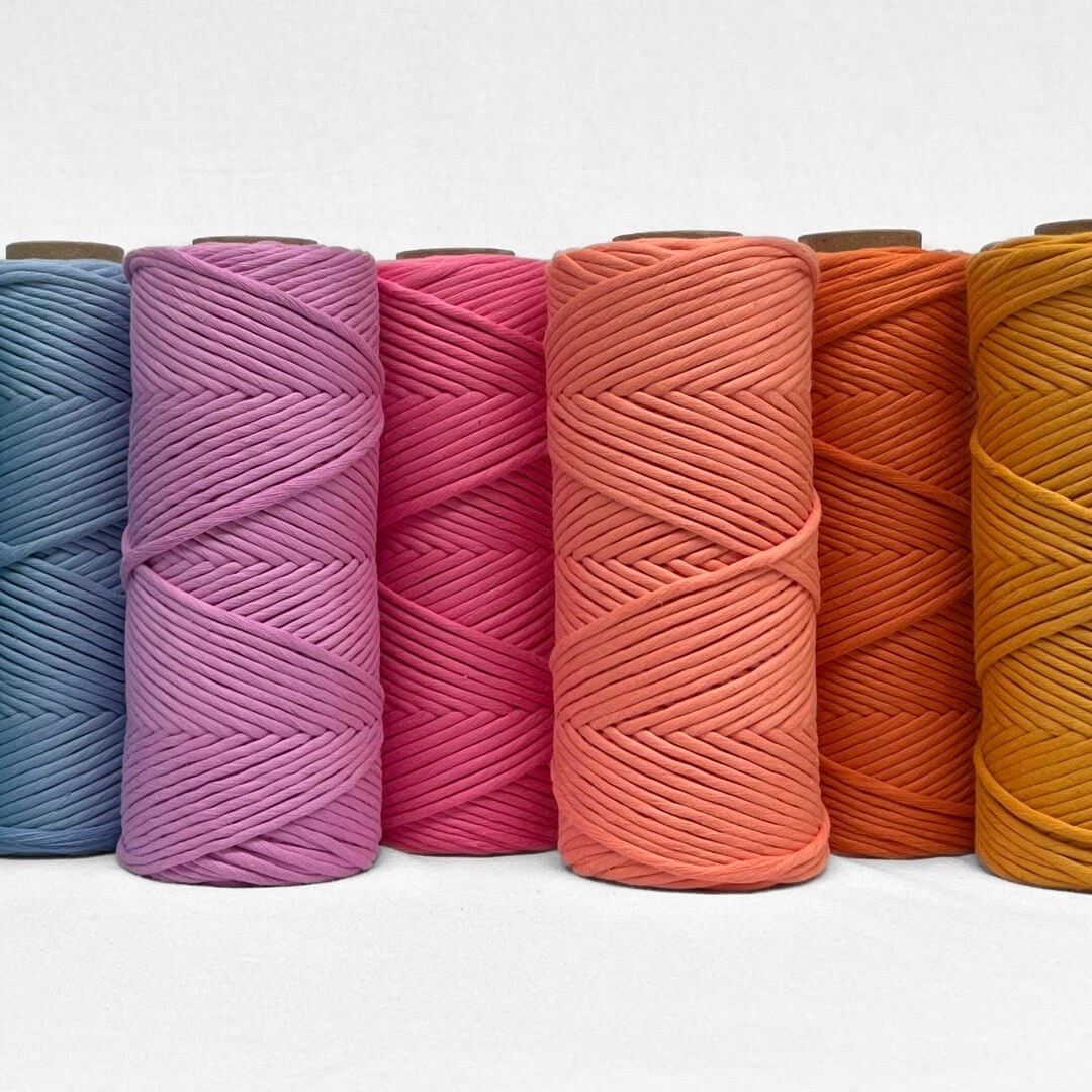 Single rolls of power pink pemium cotton cord laying flat on white background