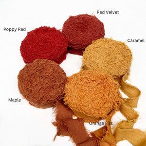 poppy red muted red caramel vibrant orange deep maple orange cotton frizz ribbon in group pohoto three rolls unravelled to sow frizzy nature