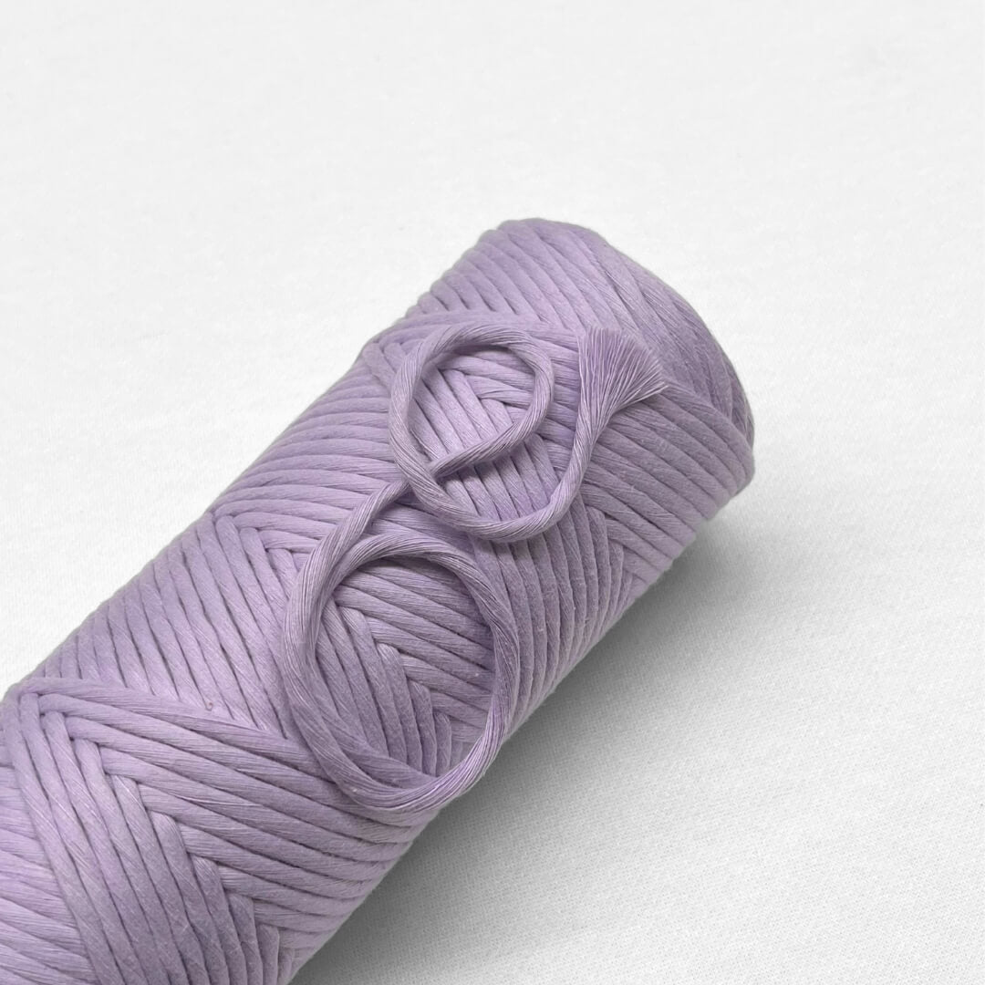 Pastel Purple macrame cord laying flat on white background 