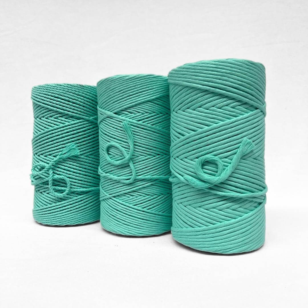 deep mint green 4mm rope cotton cord standing upright on whtie background showcasing product softness with small brushed out piece