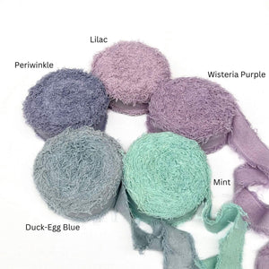 lilac soft purple vibrant mint muted blue periwinkle wide frizz ribbon for luxury gift wrapping in combination photo on white wall