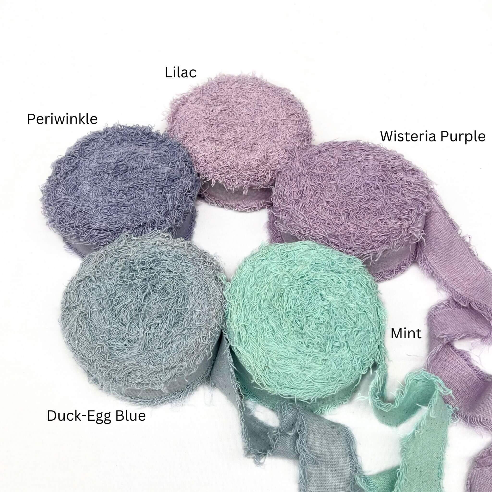 lilac soft purple vibrant mint muted blue periwinkle wide frizz ribbon for luxury gift wrapping in combination photo on white wall