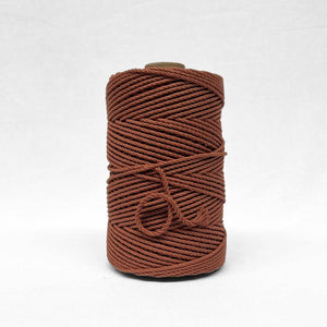 one roll of warm brown coloured cotton rope roll close up image showing texture and softness on white background