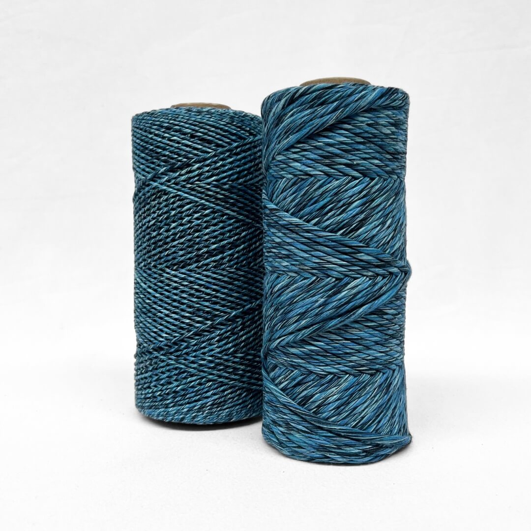 1.5 and 4mm rolls of cosmic blue mixed cotton string for weaving and macrame on white background