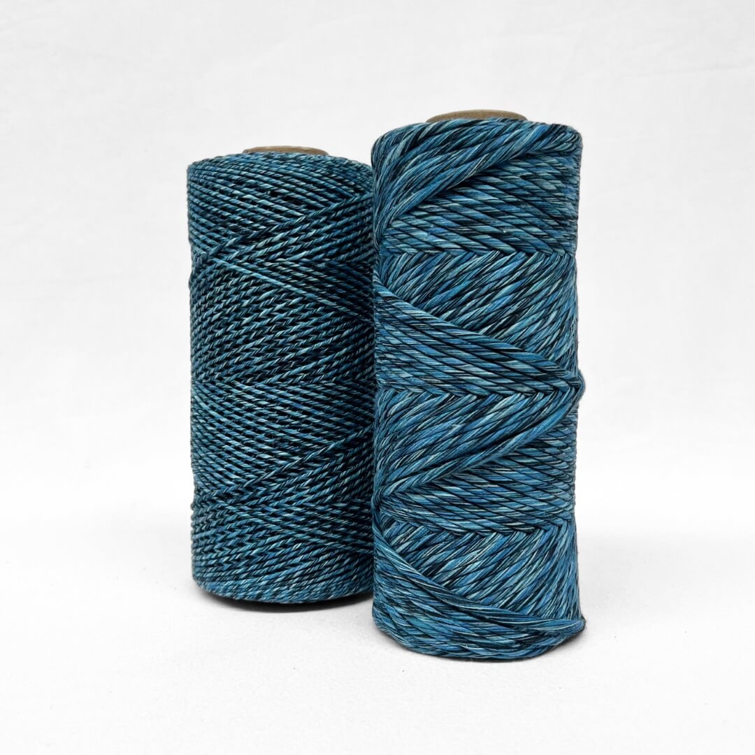 1.5 and 4mm rolls of cosmic blue mixed cotton string for weaving and macrame on white background  