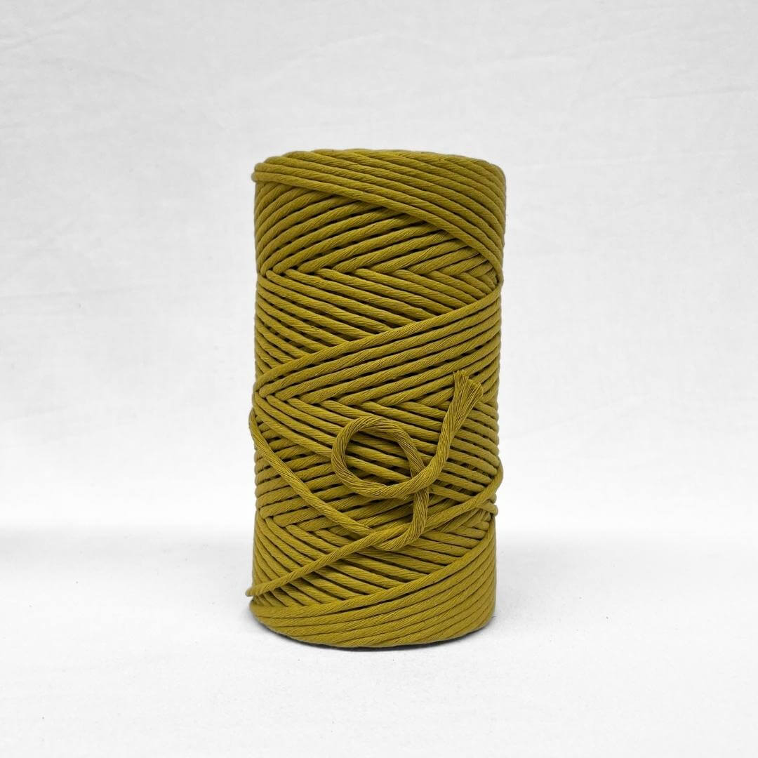 5mm cotton string roll in chartreuse yellow standing alone on white wall