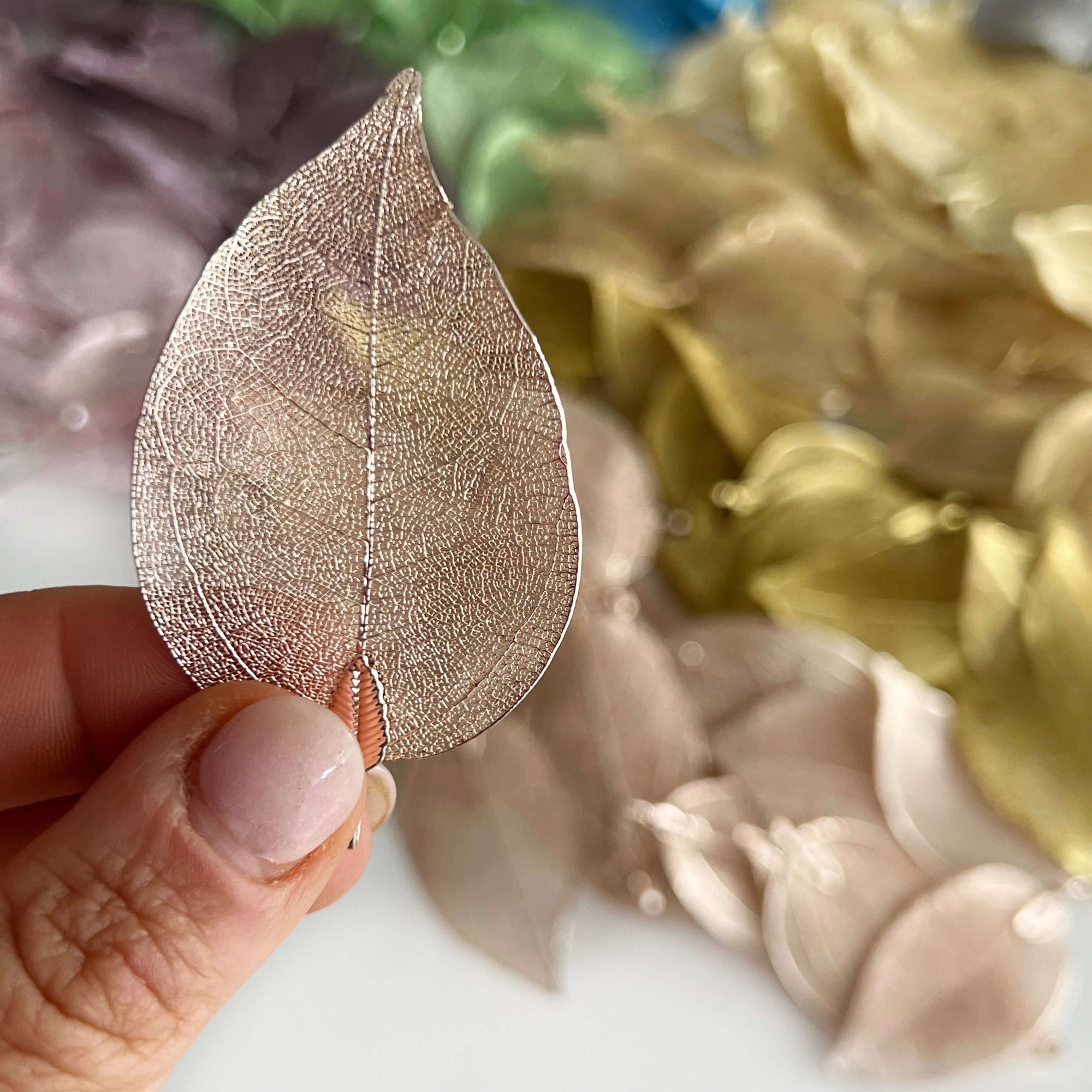 metal filigree leaves in assorted colours scattered on desk