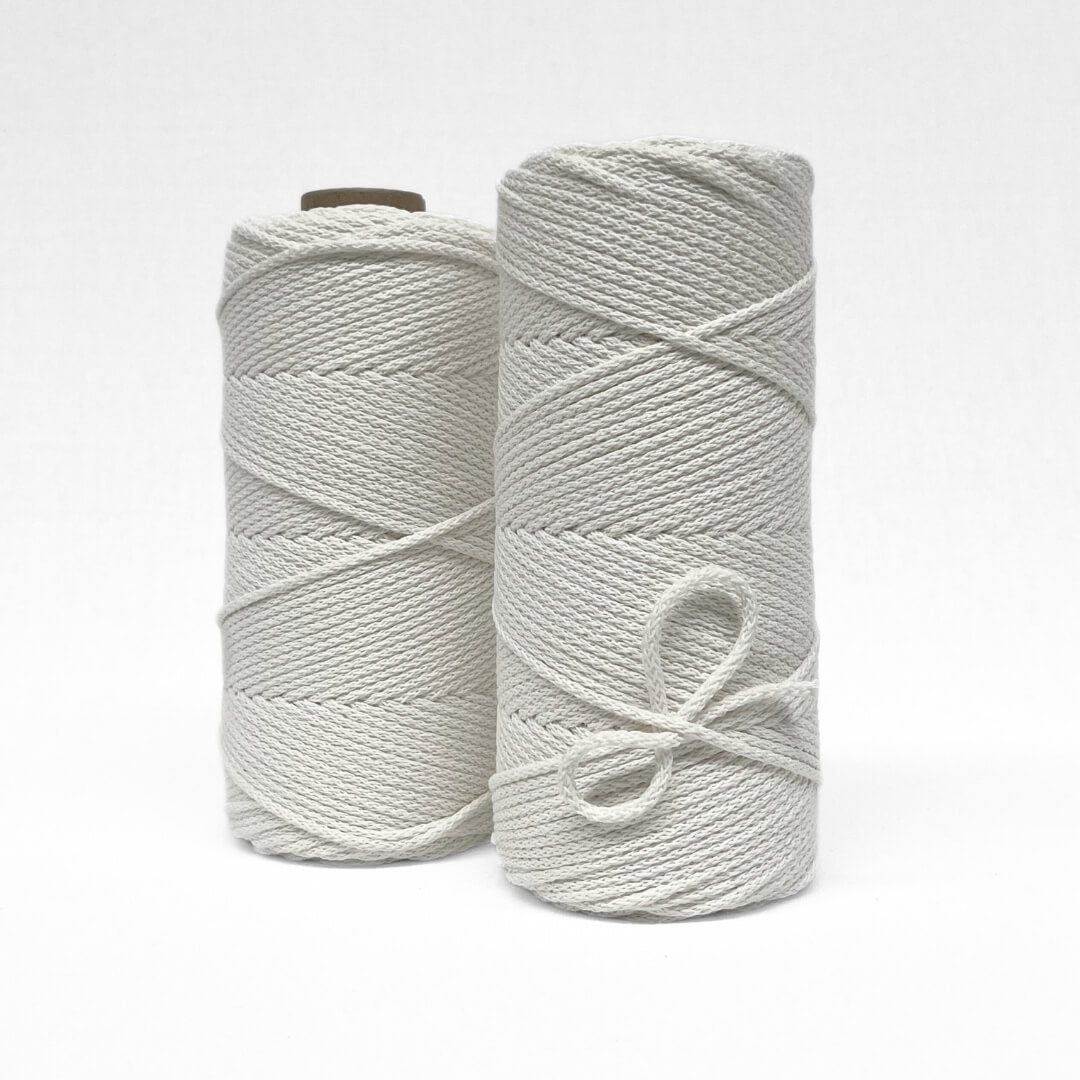 two rolls of snow white braided 4mm cord standing side by side on white background