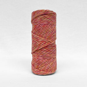 one roll of 4mm mutli coloured macrame string showing yellow pink purple red standing upright on white background