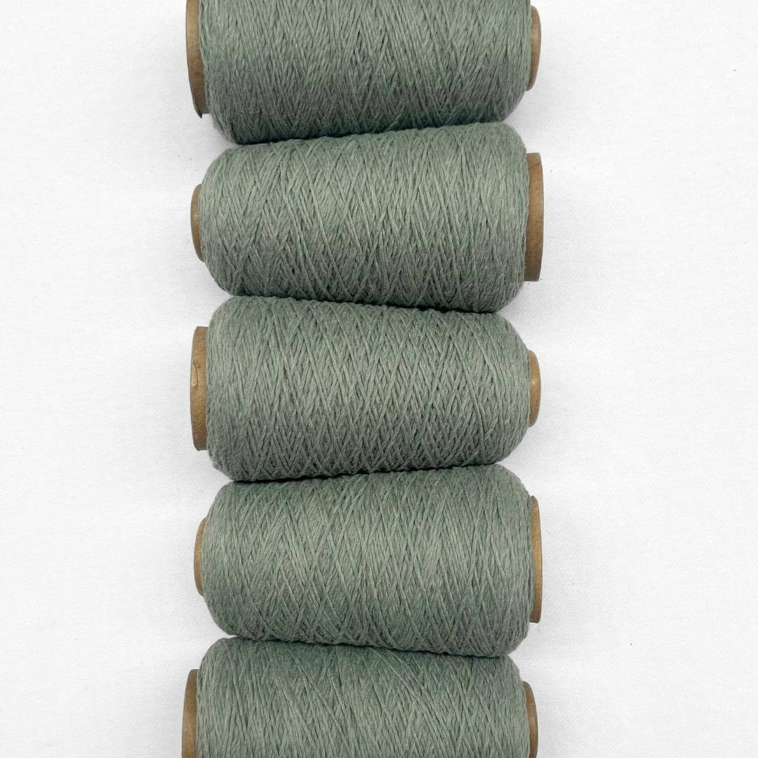 5 rolls of eucalyptus green woolen crod flaying side by side on white backdrop showing up close details 