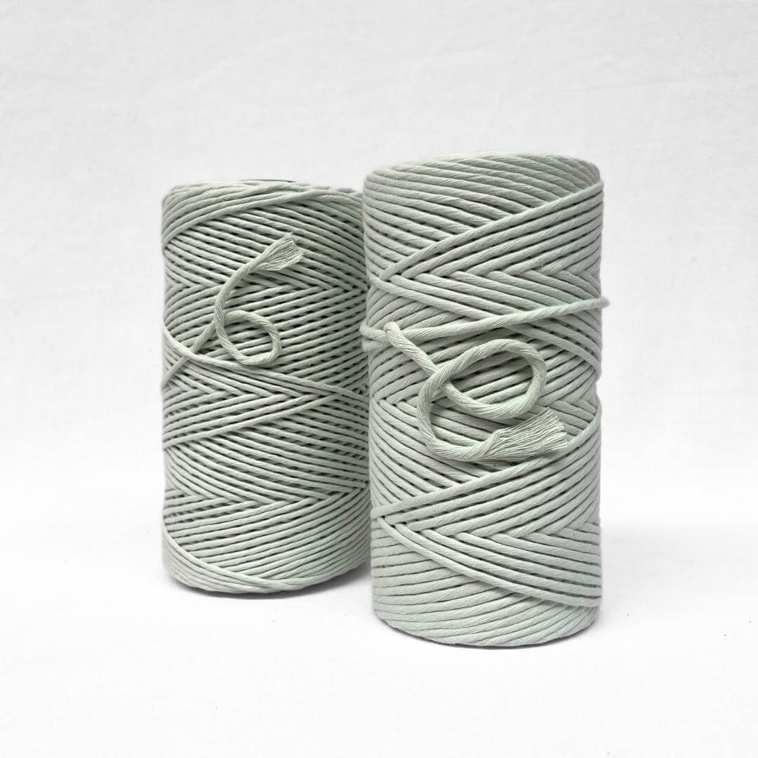 two rolls of cotton rolls standing next to each other in colour hint of mint very subtle green on white background