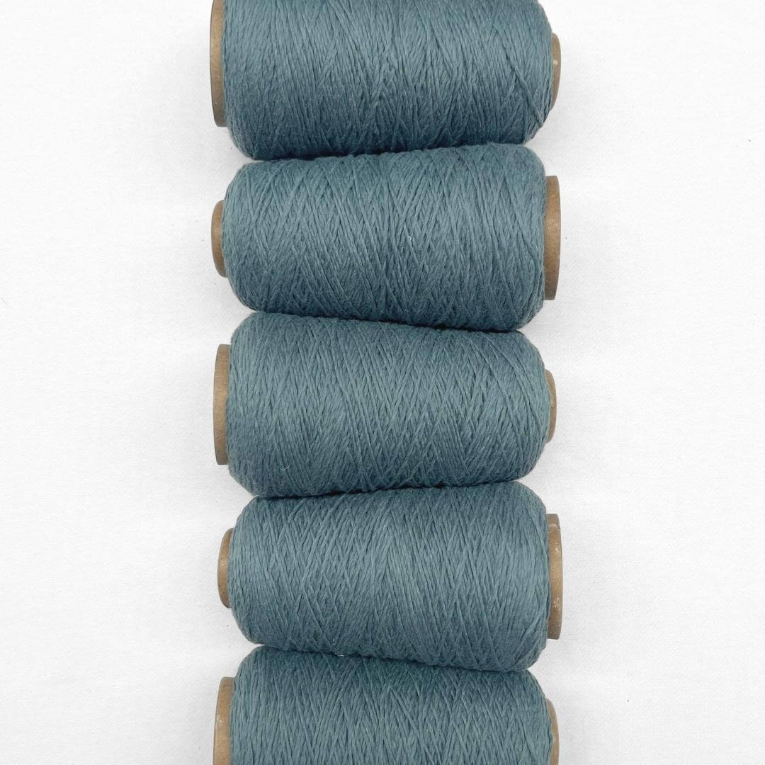 Vintage blue wool cord in flat lay style imag showing 5 cones of colour laying side by side on white back drop