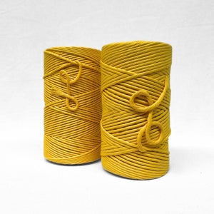 3mm and 5mm cotton string rolls in bright sunflower yellow standing next to each other showing size difference in white background