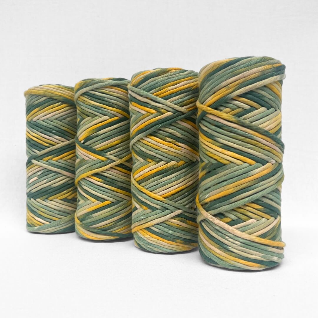 four rolls of wattle yellow and green hand painted string standing on white background