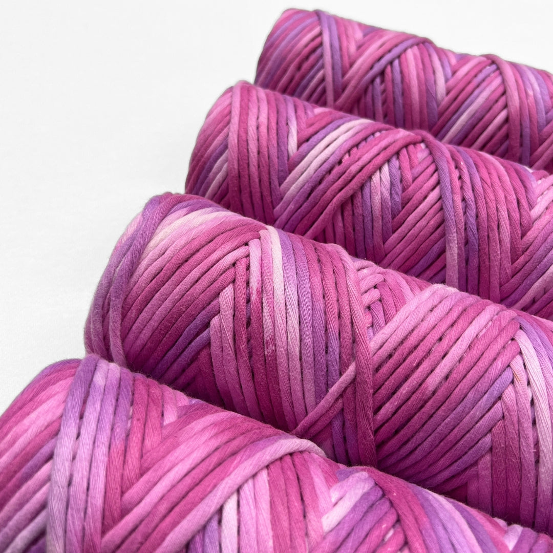 zoomed in image of very berry purple hand painted luxe cotton macrame cord laying flat on white background