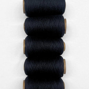 5 rolls of black wool rope laying side by side on white background 