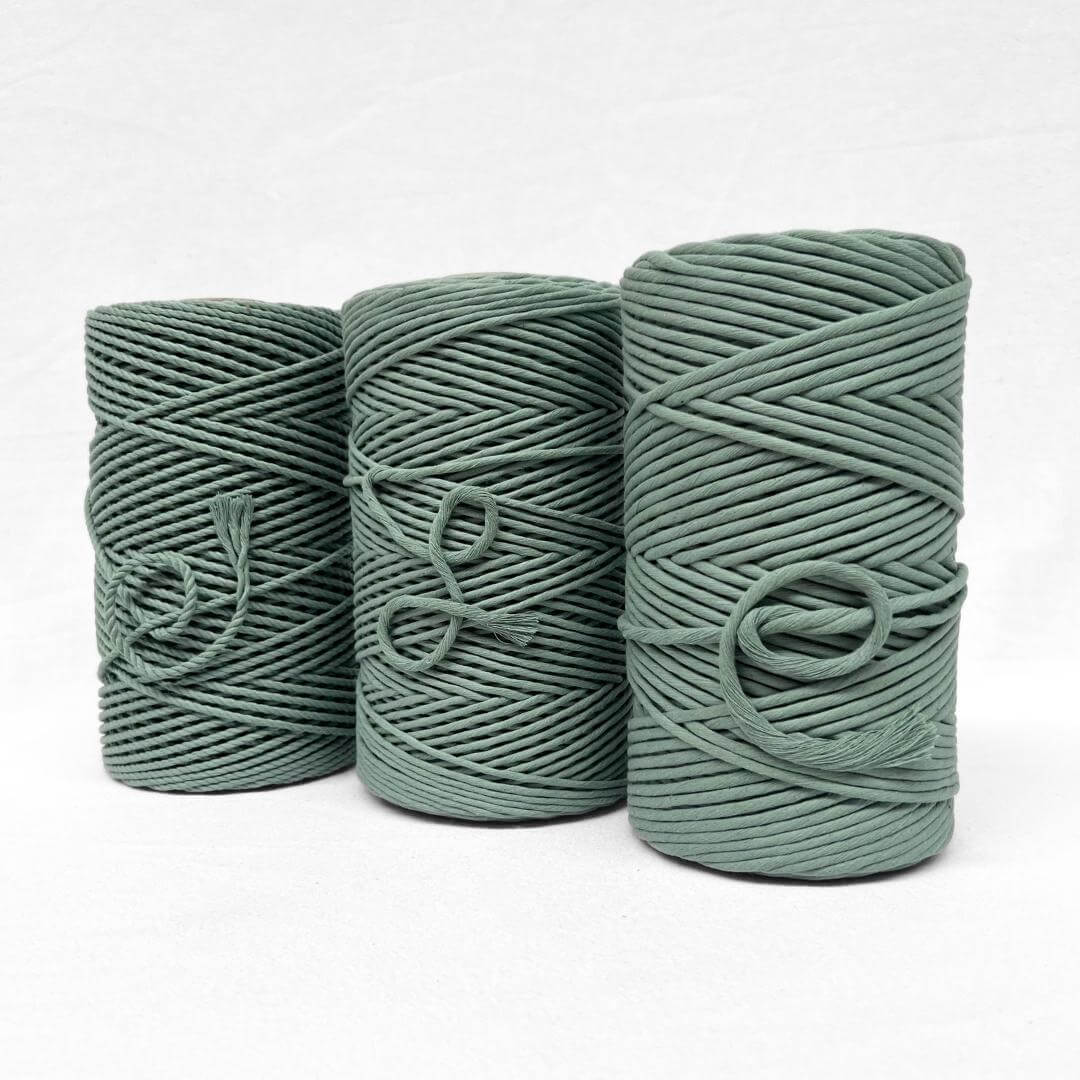 medium green cotton rope for macrame and diy projects close up image showing texture and softness on white wall