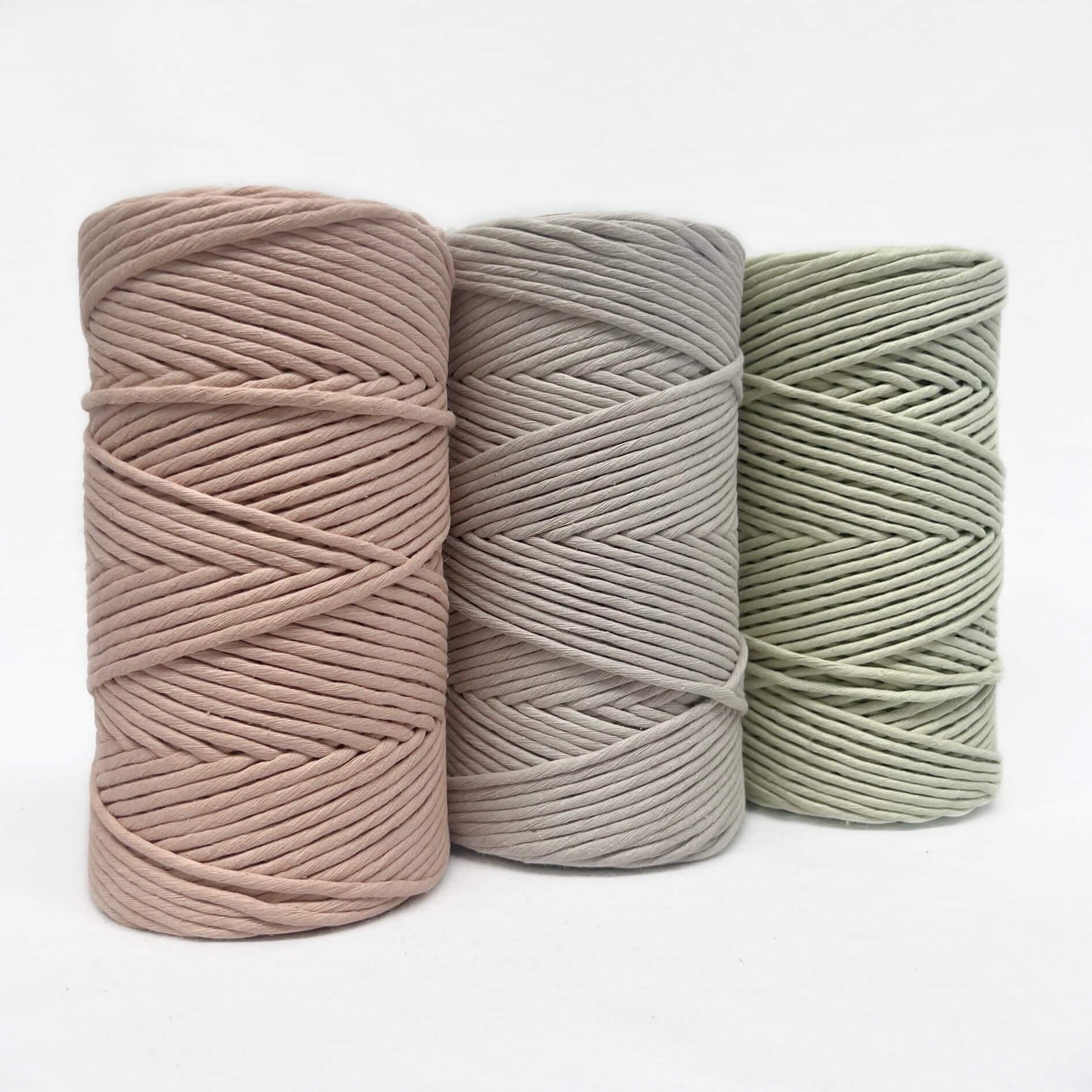 soft pink light brown light green macrame cord group photo on white wall