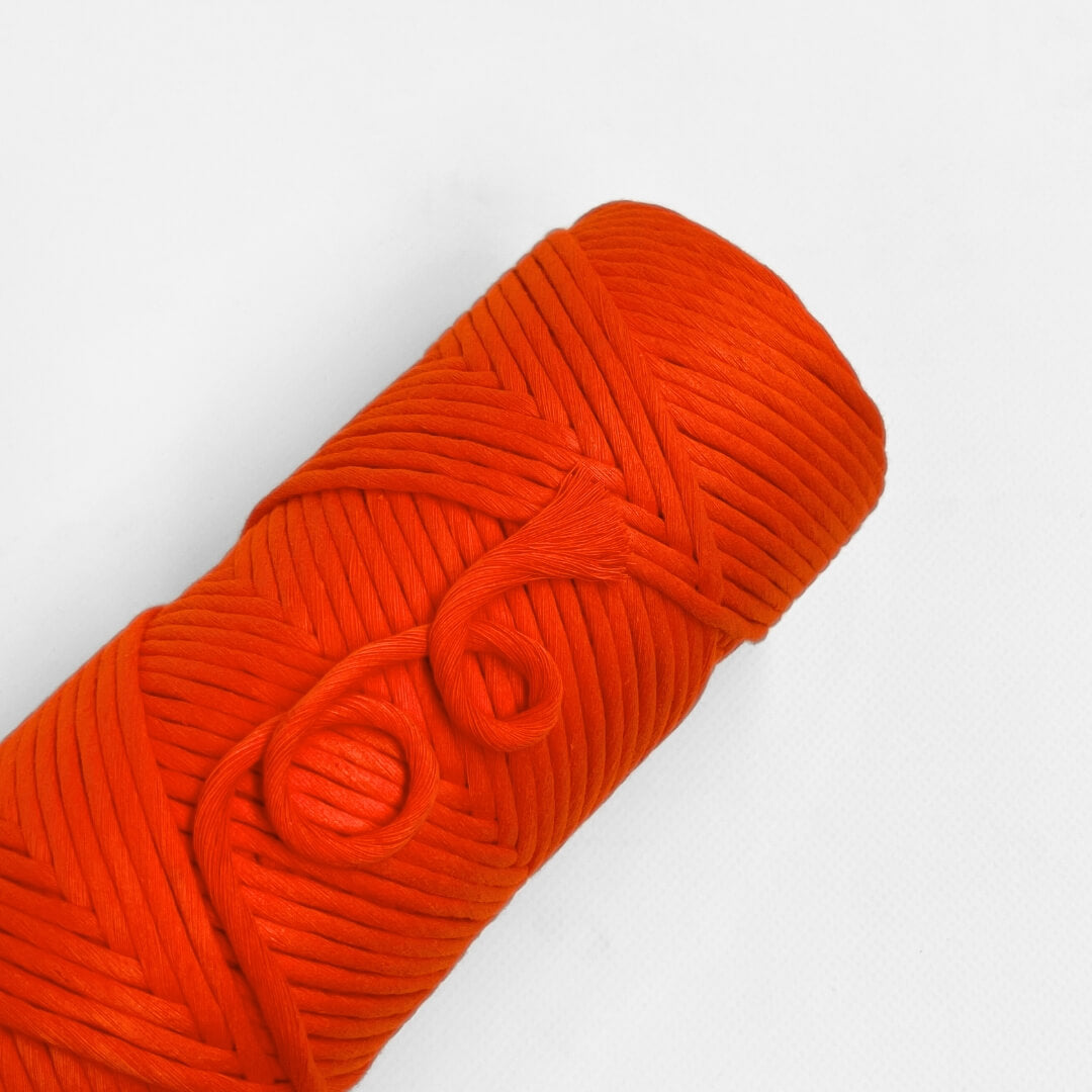 single roll of vibrant orange cloud 9 macrame string on white background