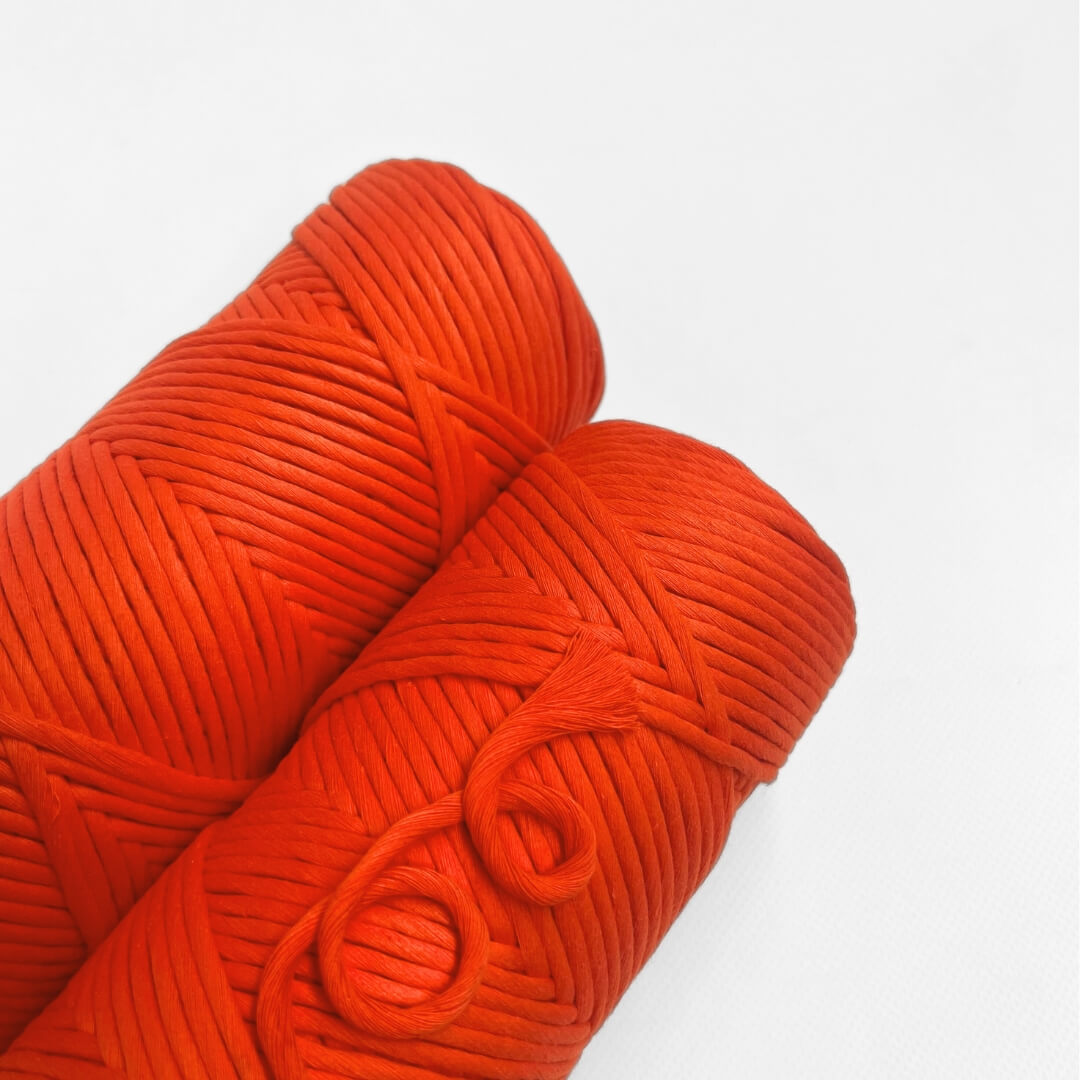 single roll of vibrant orange cloud 9 macrame string on white background